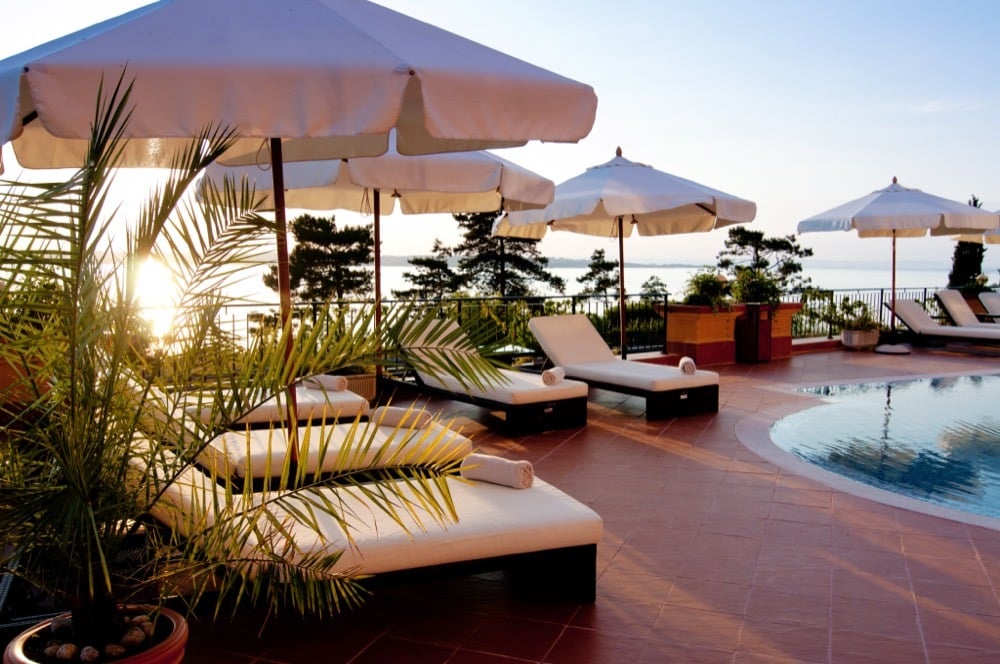 Shaded loungers and umbrellas along a resort pool deck.