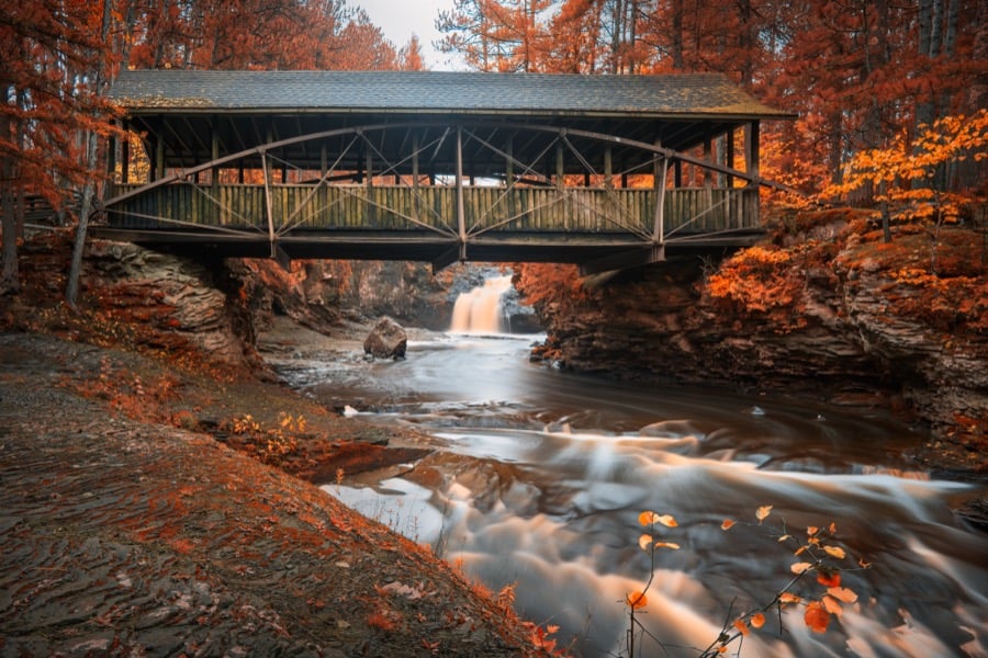 A footbridge over a rocky river gorge framed by autumn foliage in the Wisconsin Dells.